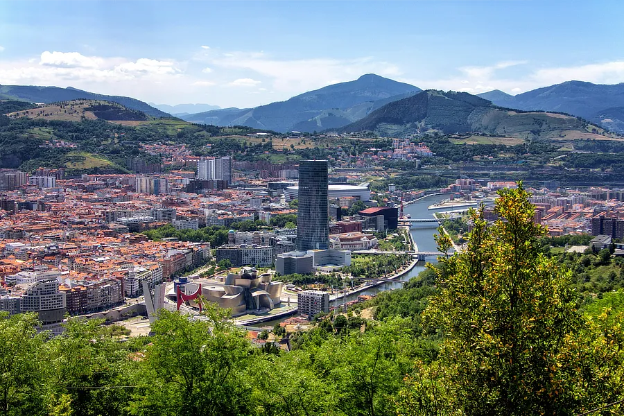 Vista aérea de la ciudad de Bilbao. Se ve la ría que cruza la ciudad y destaca la torre Iberdrola con sus 165 metros de altura en mitad de la foto. En un día abierto de sol y con pocas nubes.