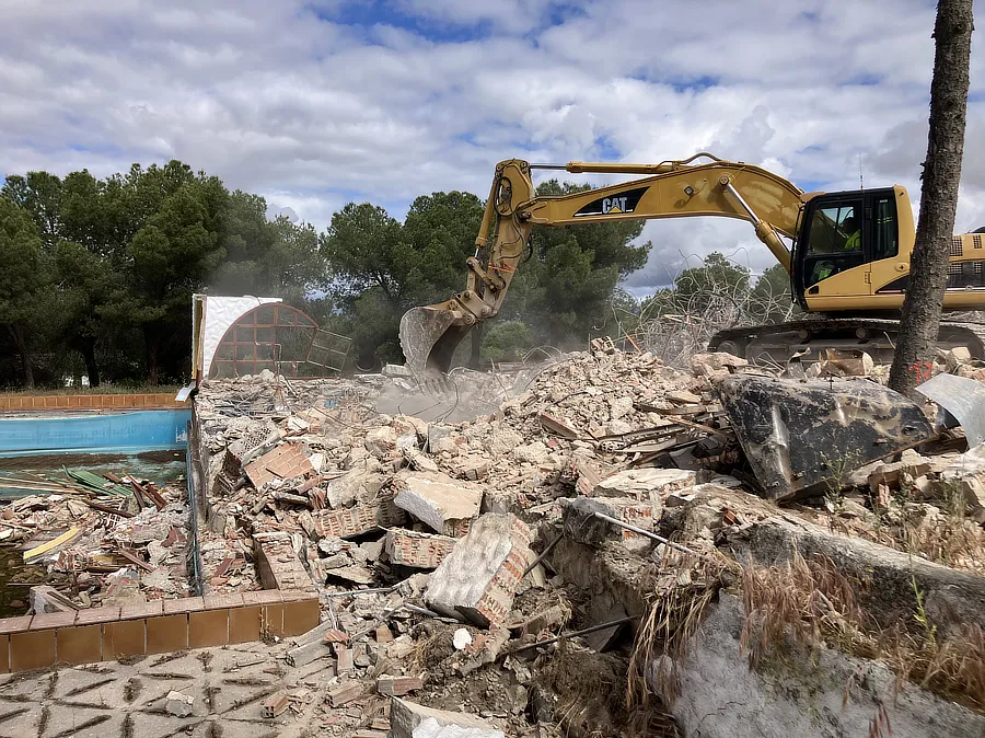 Vista de la excavadora demoliendo el chalet. 