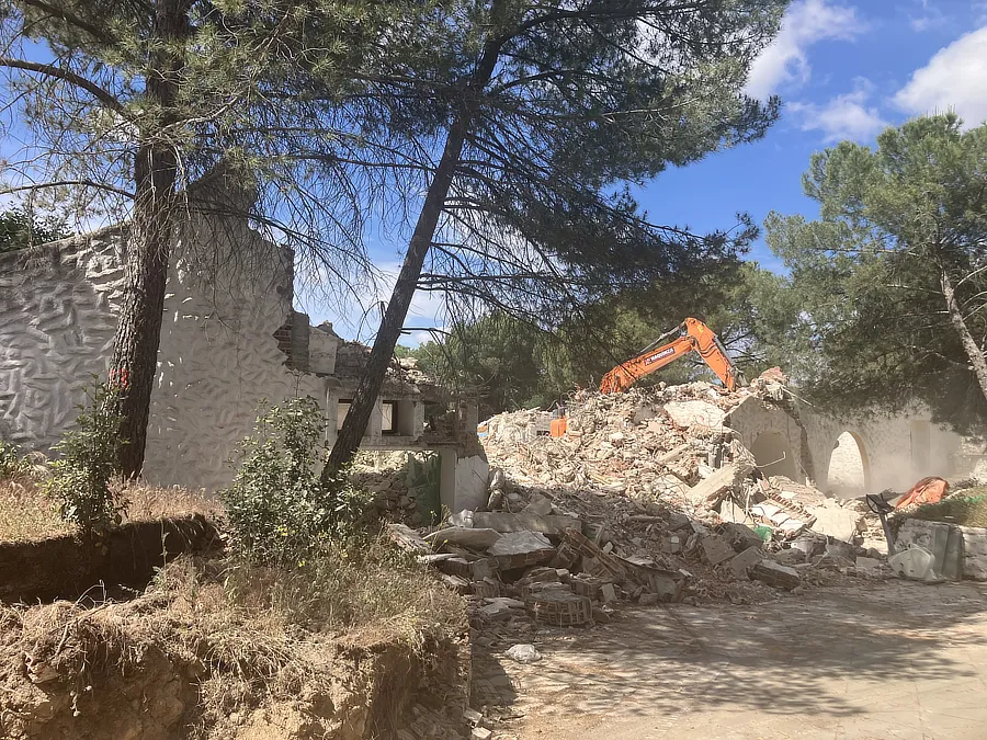 Vista de la excavadora demoliendo parte trasera del chalet. 