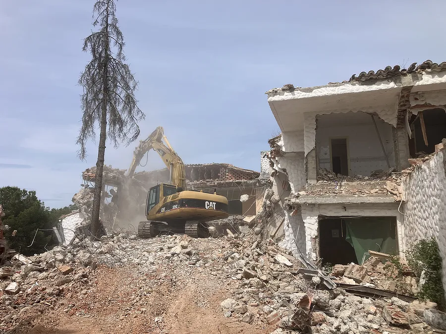 Vista de la excavadora demoliendo el chalet. 