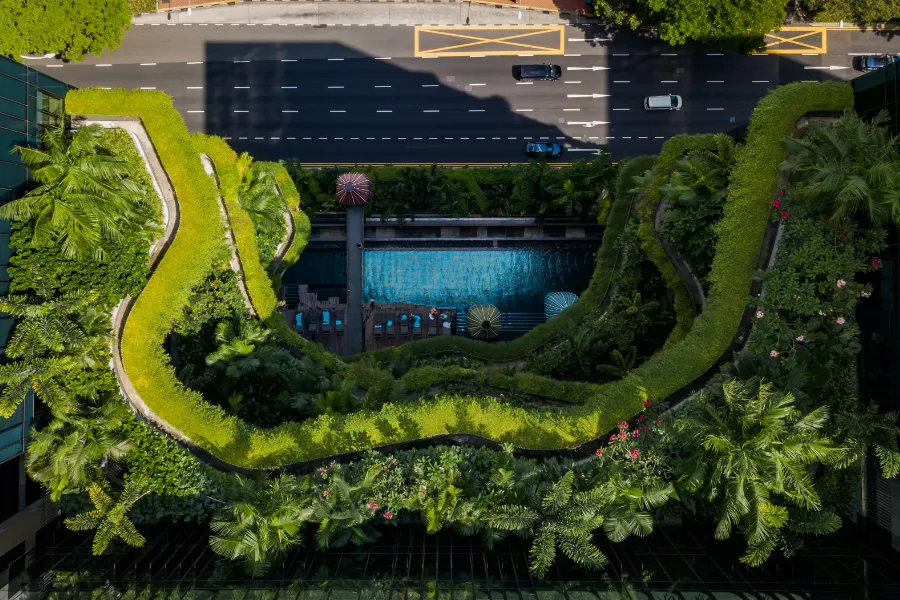 Vista de pájaro de un edificio de viviendas ecológico con una piscina comunitaria.