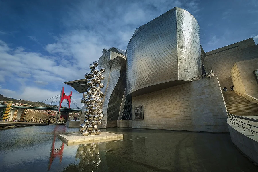 Vista exterior del Museo Guggenheim Bilbao. también se ve la escultura "El gran árbol y el ojo" realizada en acero inoxidable y acero al carbono de Anish Kapoor