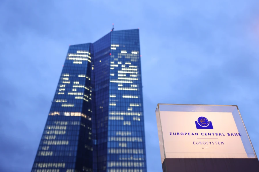 Vista del edificio del Banco Central Europeo. Junto a un poste con una placa de protegida por cristal donde se puede leer “European Central Bank / Eurosystem”.