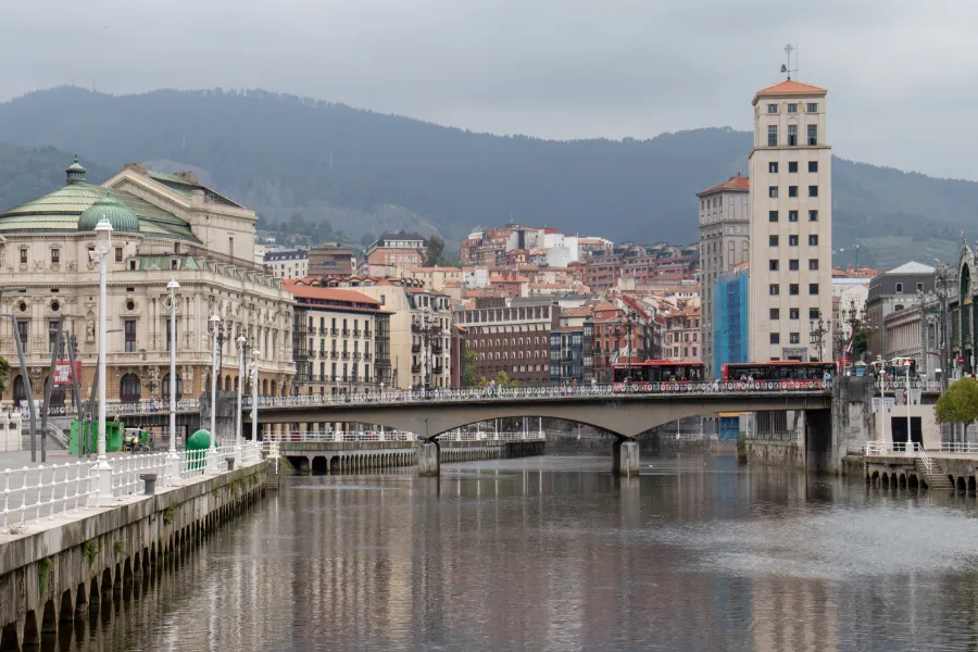 Vista de la ría de Bilbao con uno de sus puentes y varios edificios residenciales detrás al fondo