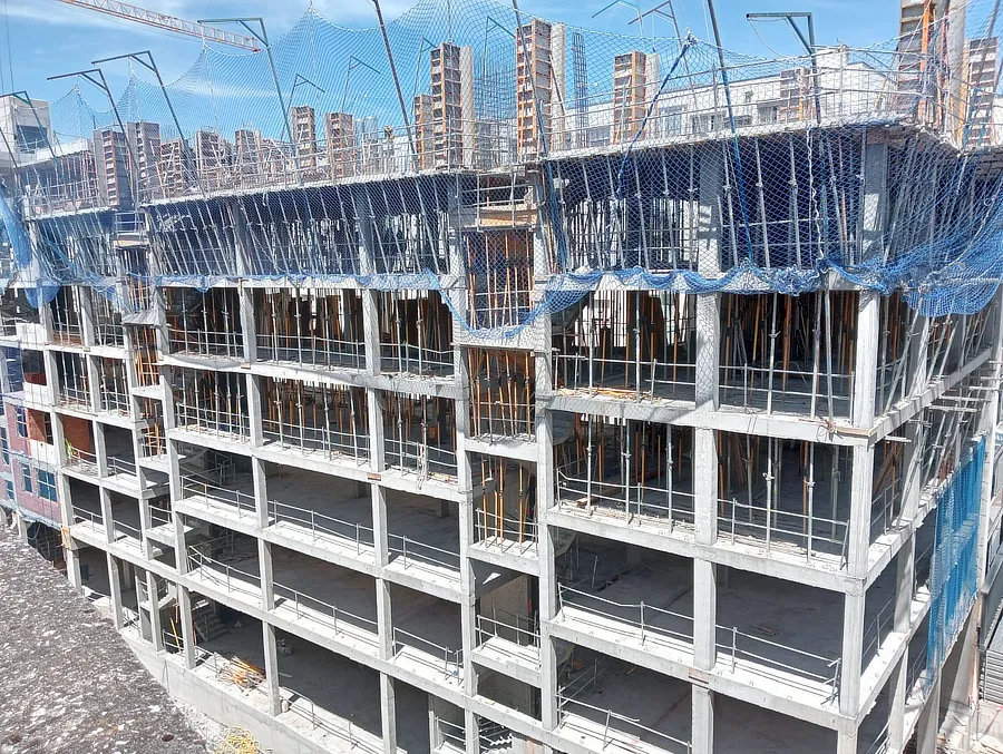 Parte de la fachada del edificio en construcción de Tu Casa en Amézola, con estructura de concreto visible y redes de seguridad en el nivel superior. Se observa una grúa y un cielo despejado de fondo. El proyecto refleja el avance continuo y el desarrollo de la nueva vivienda.